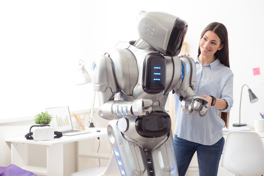 Delighted girl standing with robot