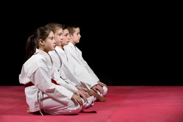 Poster Children in kimono sitting on tatami on martial arts seminar. Selective focus © fakezzz