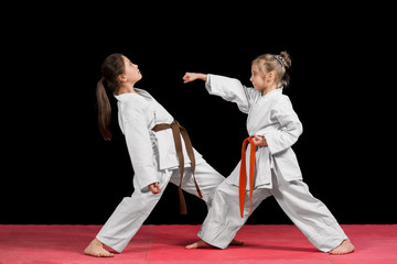 Two girls in kimono are training paired exercises karate