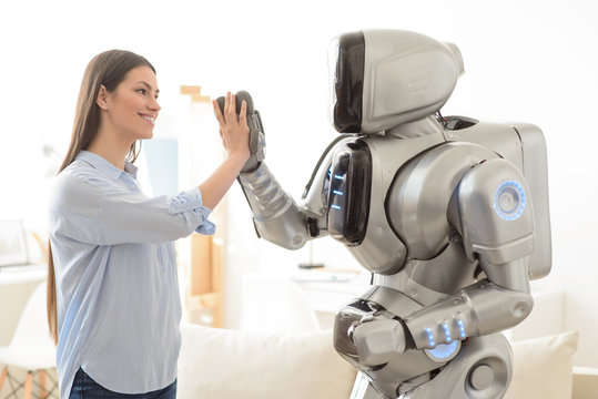 Positive  girl and robot giving high five 