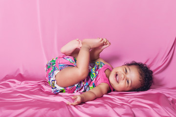 Obraz na płótnie Canvas Cute baby girl portrait laughing while lying