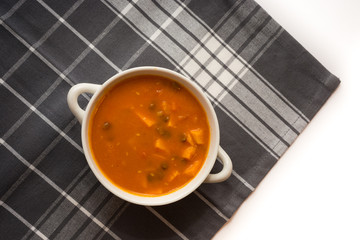 Sweet potato, carrot and green lentil soup with coconut milk and canned tomatoes on the gray tablecloth