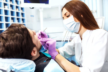 Obraz premium Overview of dental caries prevention.man at the dentist's chair during a dental procedure.