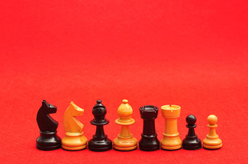 Row of chess pieces displayed on a red background