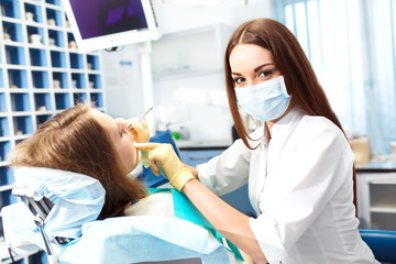Professional woman dentist doctor working . woman at dental clinic. lady woman at dentist taking care of teeth.Dental care for people. Dentist holding dental device for fixing teeth.
