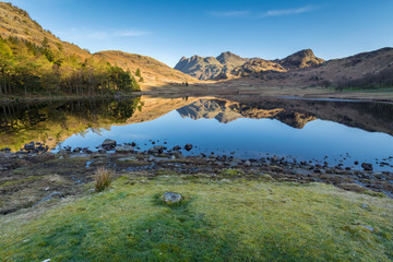 Naklejka premium Wide angle view of Blea Tarn in the English Lake District on a sunny spring morning with clear sky and reflections.