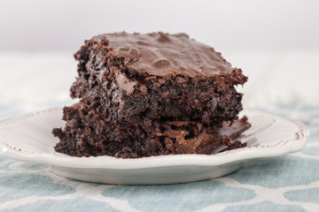 Dark chocolate brownie on a blue and white place mat