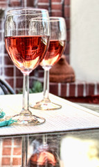 Two glasses with rose wine on a patio table