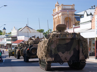 Anzac Day Parade with armoured vehicles driving down main street of town