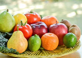 Natural-looking fruits and kale on woven basket