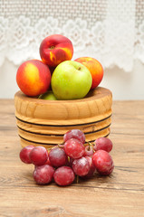 Apples, nectarines and grapes displayed in a wooden bowl
