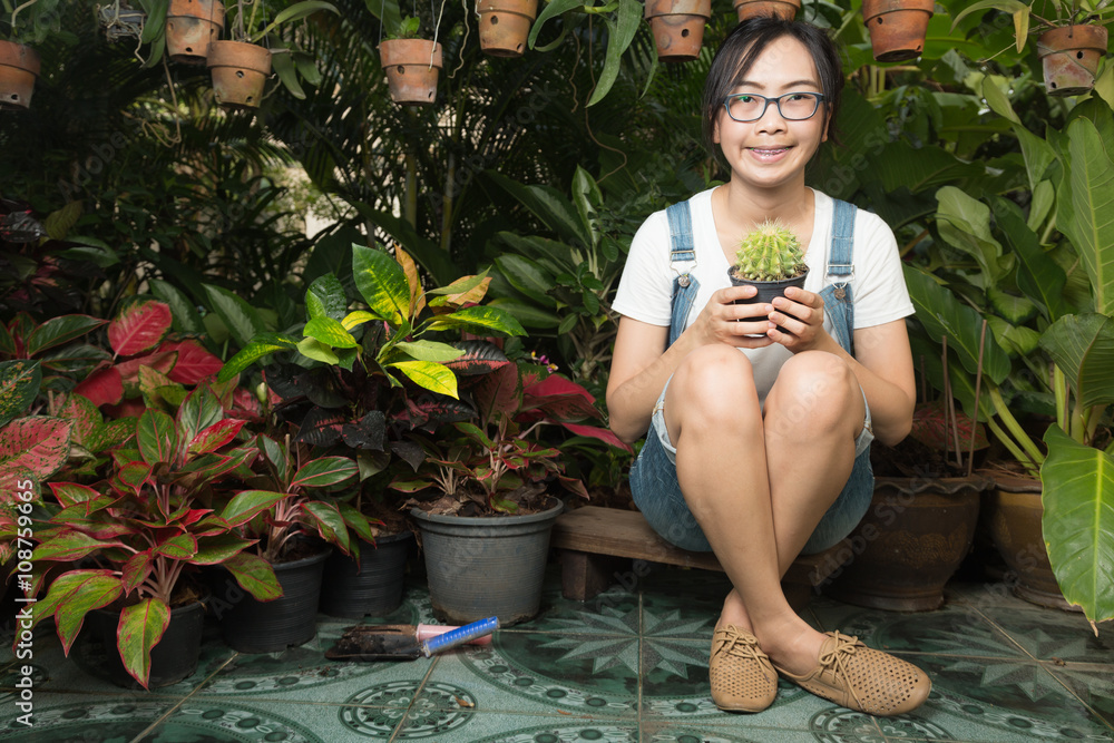 Wall mural woman holding a cactus