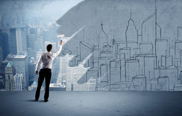 Elegant salesman repainting the city on wall