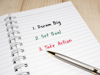 Dream Big, Set Goal , Take Action, handwriting on notebook with wood background