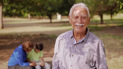 Old and young people together, elderly and children in family. Happy grandfather smiling at camera, wife helping kid with school homework, studying with book, senior man portrait - Powered by Adobe