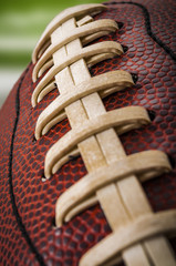 Macro of a vintage worn american football ball with visible laces, stitches and pigskin pattern