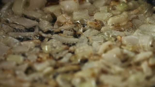 Frying sliced onions in a pan closeup