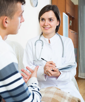 Doctor examinating teen boy with quinsy at home
