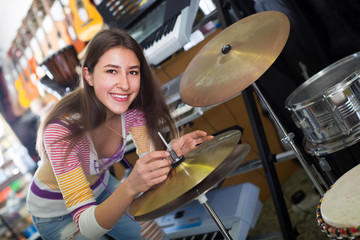 Fototapeta na wymiar Young girl selecting drums and accessories