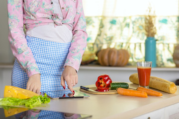 Woman cooking Salad using Recipe on screen of Tablet