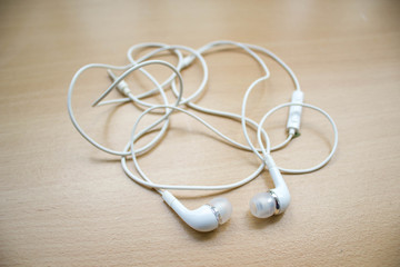 white earphone on wood table