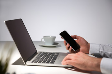 Businessperson using laptop and smartphone