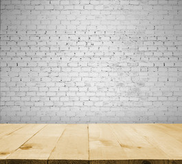 image of wooden table in front of empty white brick textured wal