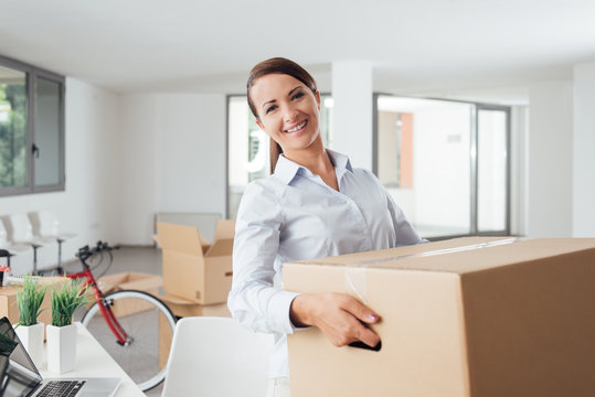 Happy Woman Carrying Boxes Into Her New Office