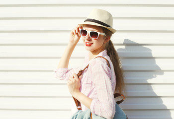 Fashion pretty woman in sunglasses and hat over white background