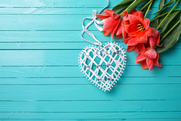 Spring tulips and  decorative heart  on teal  painted wooden bac