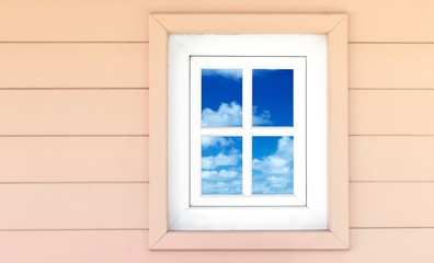 Holzfenster mit Aussicht auf blauen Himmel mit Wolken