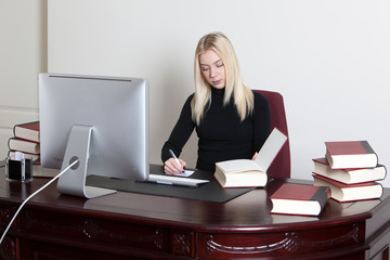 businesswoman writes a paper and holding book in office