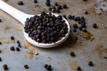 black peppercorn seeds on steel plate