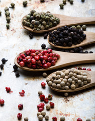 color peppercorn seeds on wooden spoons