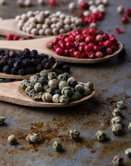 color peppercorn seeds on wooden spoons