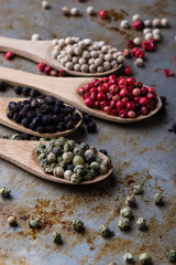 color peppercorn seeds on wooden spoons