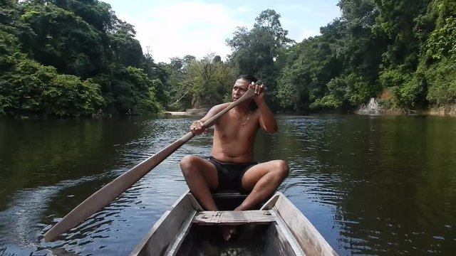 Arowak Indian in a dugout paddling
