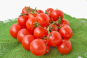 Tomatoes on the green gunny cloth on the white background