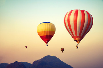 Naklejka premium Hot air balloon over mountain on sky sunset , vintage and retro filter effect style