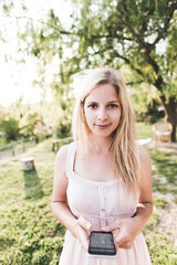 Obraz premium Young blonde woman using cell phone outdoor. 