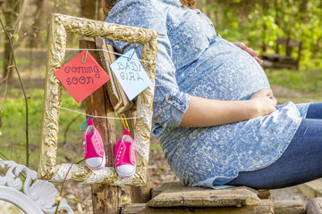 Pregnant woman outdoor in the park on bench