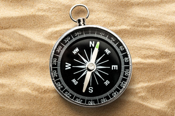 Fototapeta na wymiar Black compass on the sand