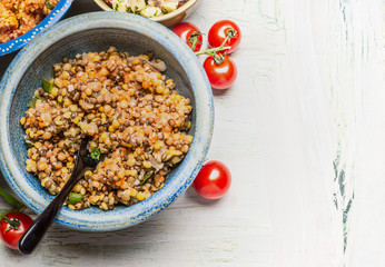 Red lentil salad in bowl with spoon on light rustic background, top view, place for text