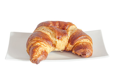 Brown croissant with butter on a white plate, close up, white background