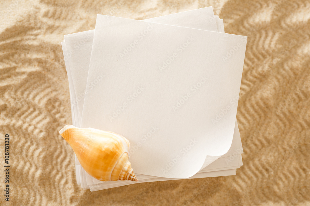 Wall mural Blank white paper and seashell in sand