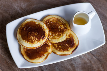 Delicious homemade pancakes with honey on a white plate