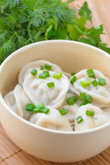 Meat pelmeni with butter and spring onion