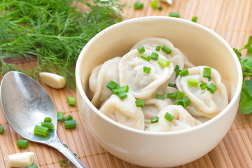 Meat pelmeni with butter and spring onion