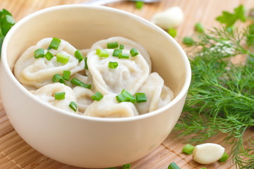Meat pelmeni with butter and spring onion