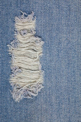 Blue jeans background closeup view to torn texture.